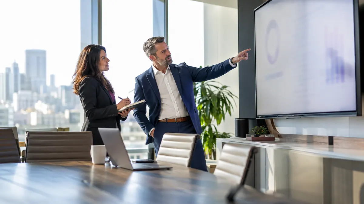 Business leaders discussing operational information on a boardroom display.