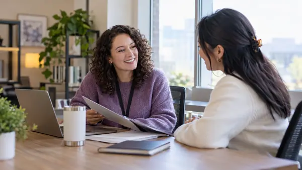 HR coordinator discussing onboarding materials with a new employee.